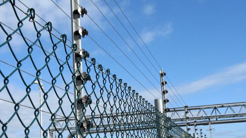 A view looking up at electric security fencing infrastructure
